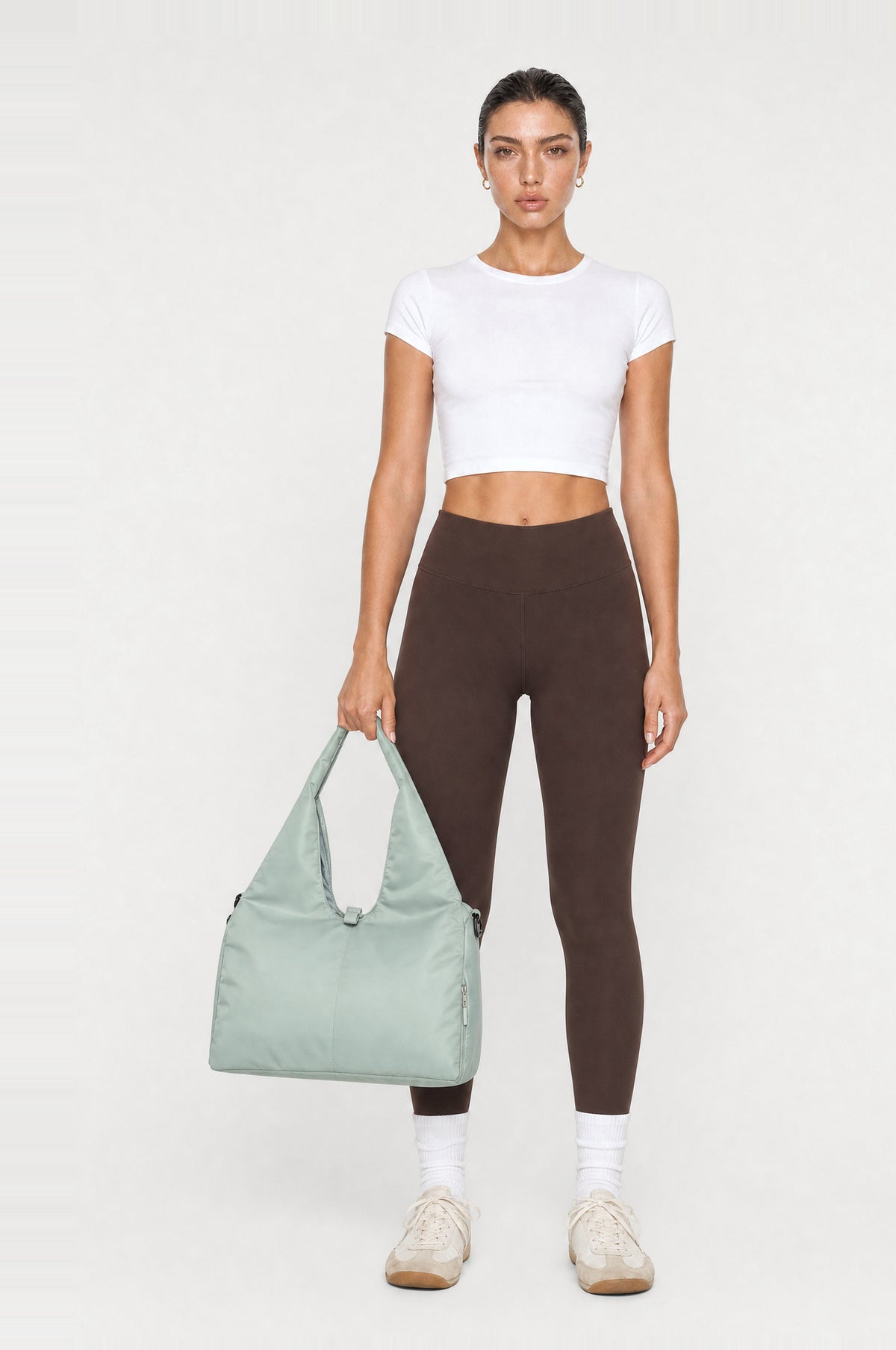 The Greenwich Travel Bag in Mint, front, held by the handle