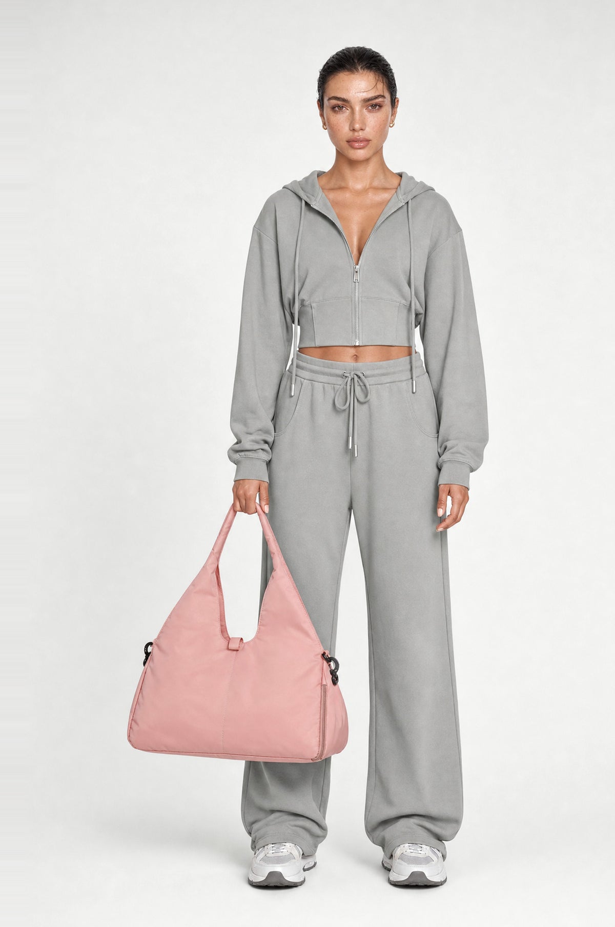 The Greenwich Travel Bag in Pink, front, held by the handle