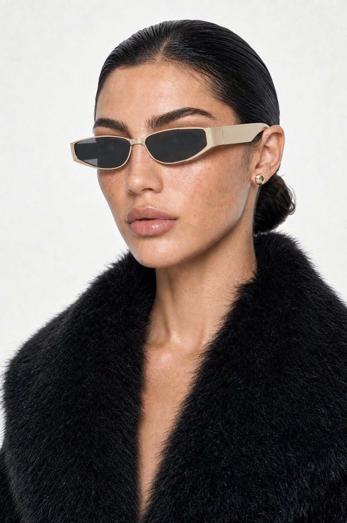 The Putney Wrap Sunglasses in Gold, worn, three-quarter