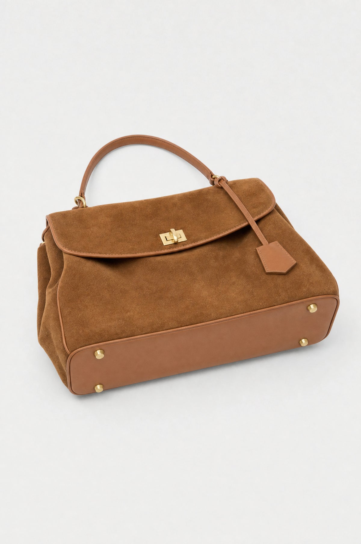 The Kensington Top-Handle Bag in Caramel, smooth leather base with gold-tone feet