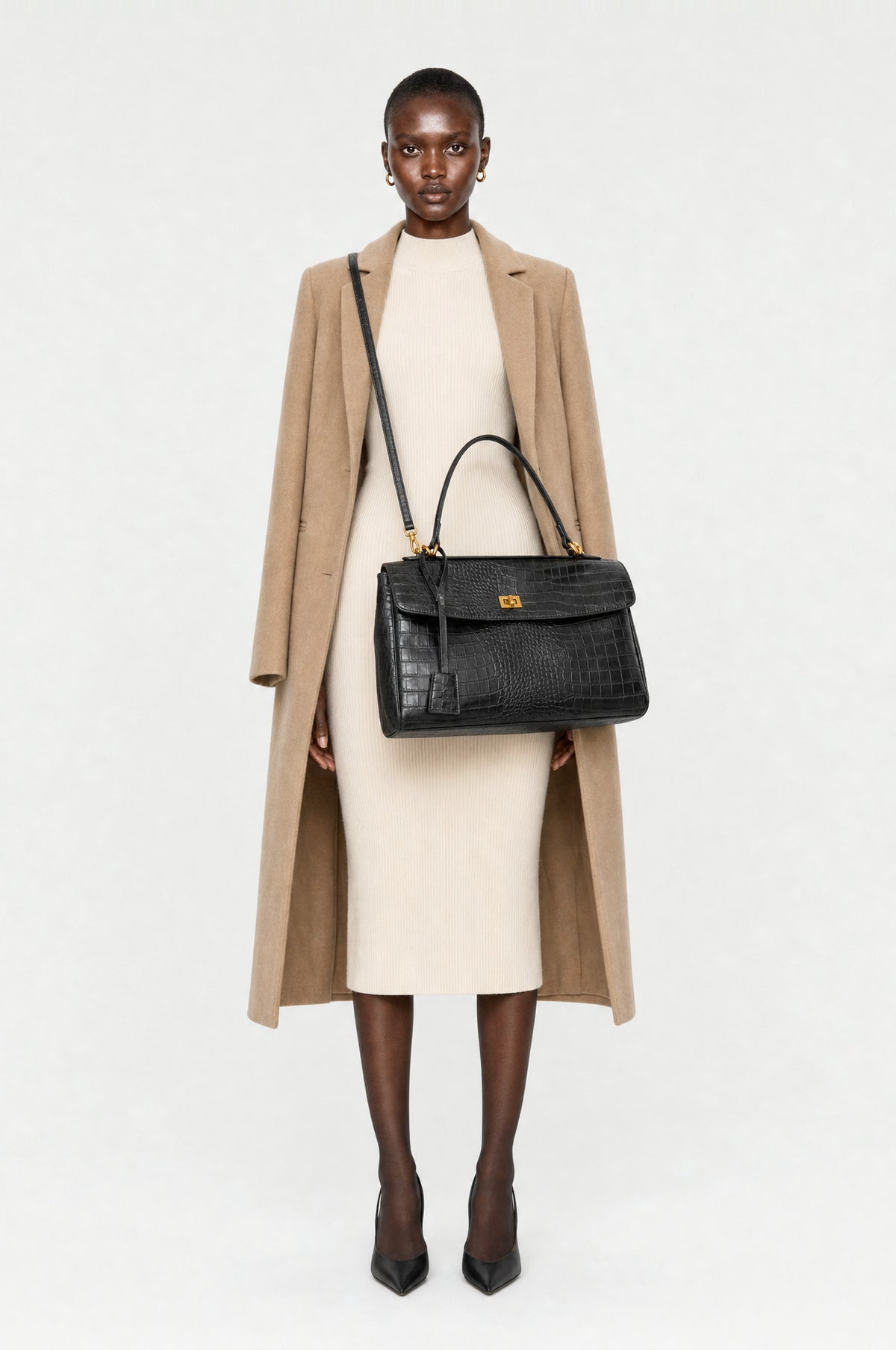 The Marylebone Croc-Effect Tote in Black, worn crossbody on the detachable strap