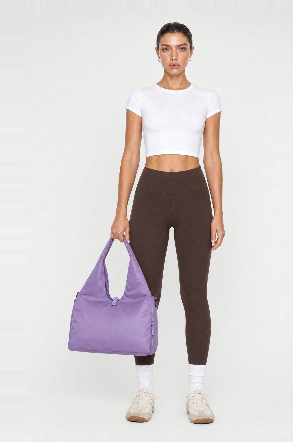The Greenwich Travel Bag in Lilac, front, held by the handle