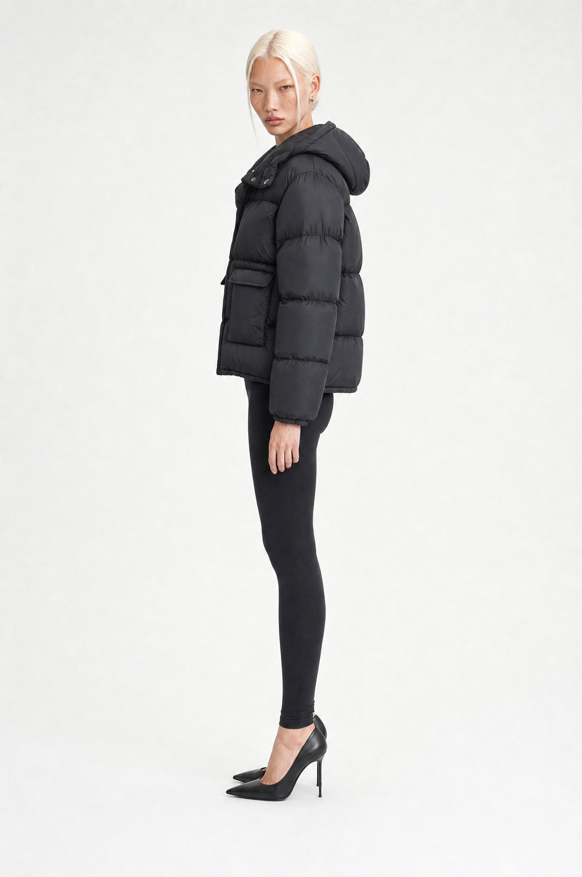 The Richmond Hooded Puffer in Black, side, looking at camera