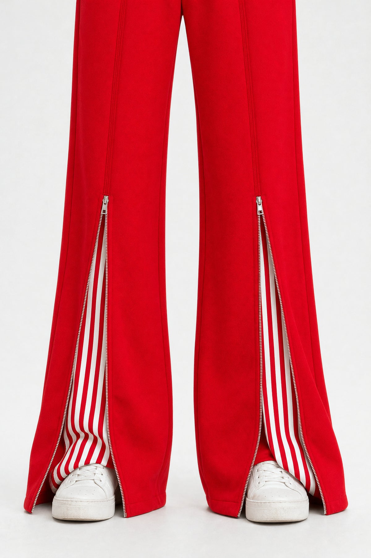 Close-up of the Islington trousers in red, zipped hem slits open onto a striped insert